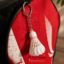 Mini badminton shuttlecock keychain attached to a badminton racket bag zipper